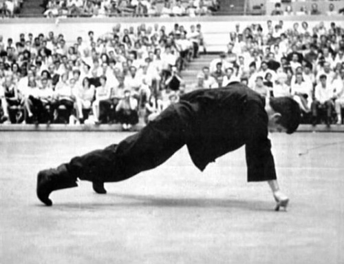 Bruce Lee doing a one-handed two-finger push-up.