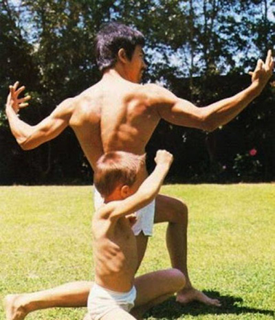 Bruce Lee weight training bodybuilding side pose with son Brandon Lee