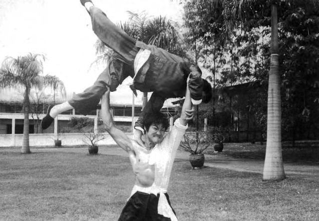 Bruce Lee strength power muscles lifting man over his head and throwing him